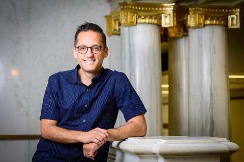 Professor Cisneros posing in front of some marble columns.