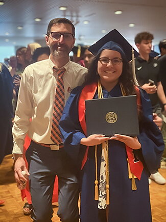 Chavarria standing with Neil Baer holding diploma